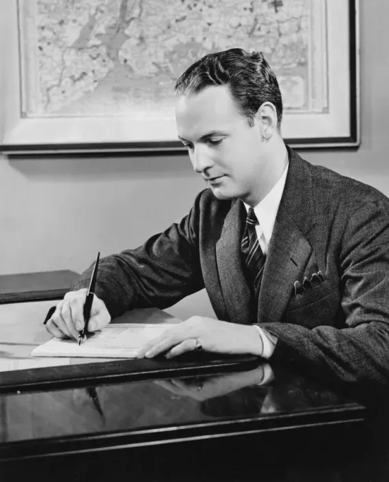 Framed Print : Young businessman sitting at desk, writing, (B&W) Framed Print : Young businessman sitting at desk, writing, (B&W)