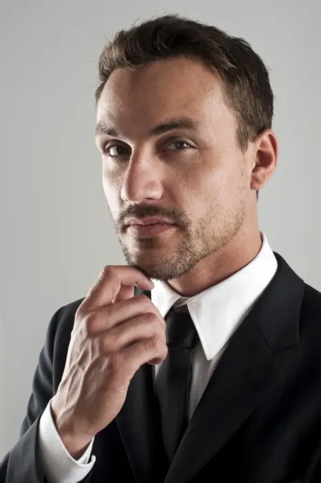 Framed Print : Young businessman wearing a suit with his hand on his chin, pensive, portrait Framed Print : Young businessman wearing a suit with his hand on his chin, pensive, portrait