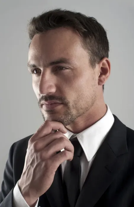 Framed Print : Young businessman wearing a suit with his hand on his chin, pensive, portrait Framed Print : Young businessman wearing a suit with his hand on his chin, pensive, portrait