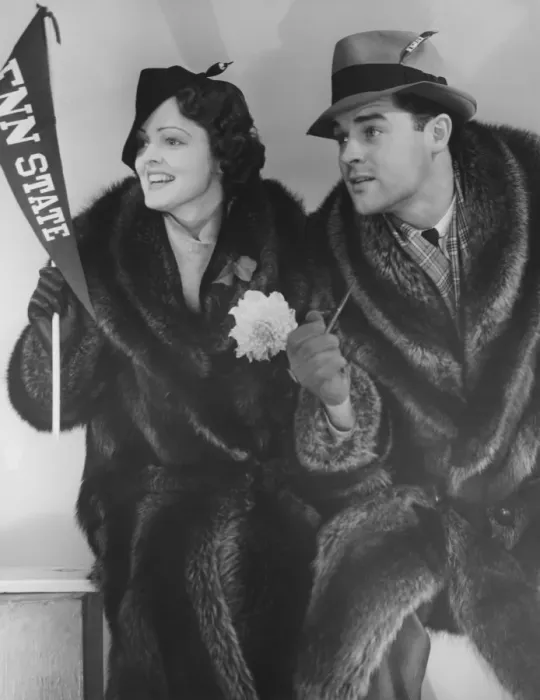 Framed Print : Young couple in fur coats sitting, facing same direction, (B&W) Framed Print : Young couple in fur coats sitting, facing same direction, (B&W)