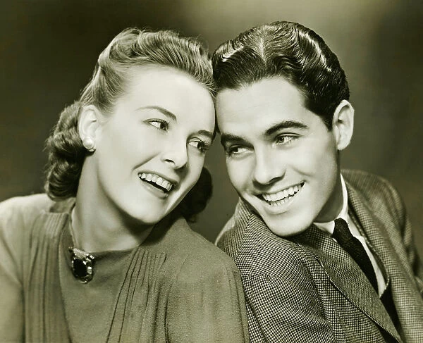 Young couple with head to head, smiling, (B&W)