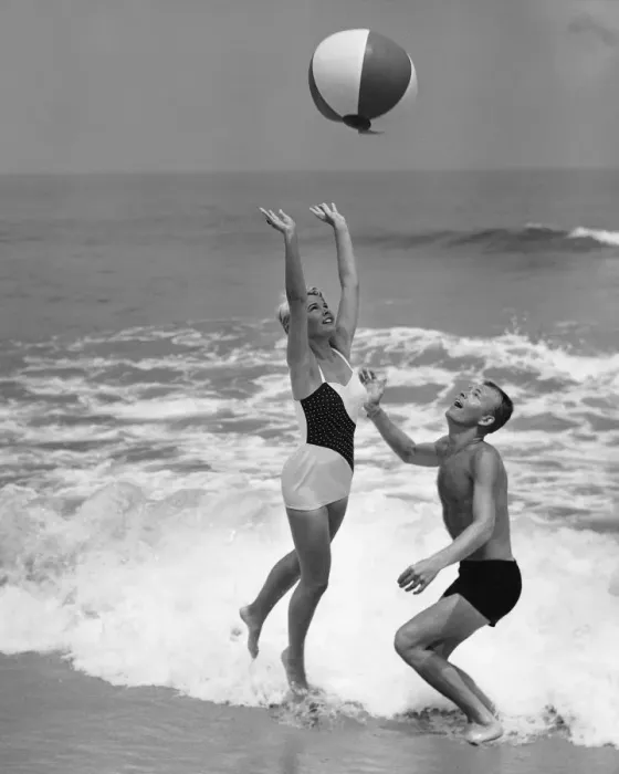 Framed Print : Young couple playing with beach ball at waters edge Framed Print : Young couple playing with beach ball at waters edge
