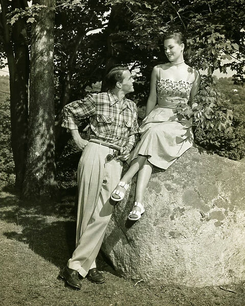 Young couple posing in park, (B&W)