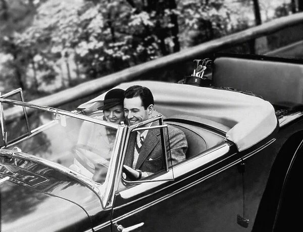 Young Couple in Vintage Soft Top Car with Golf Clubs on Back Seat
