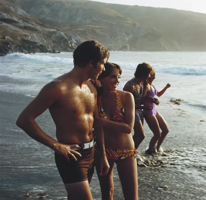 Framed Print : Young couples standing on beach, smiling