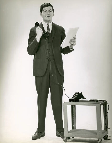 Young executive holding telephone