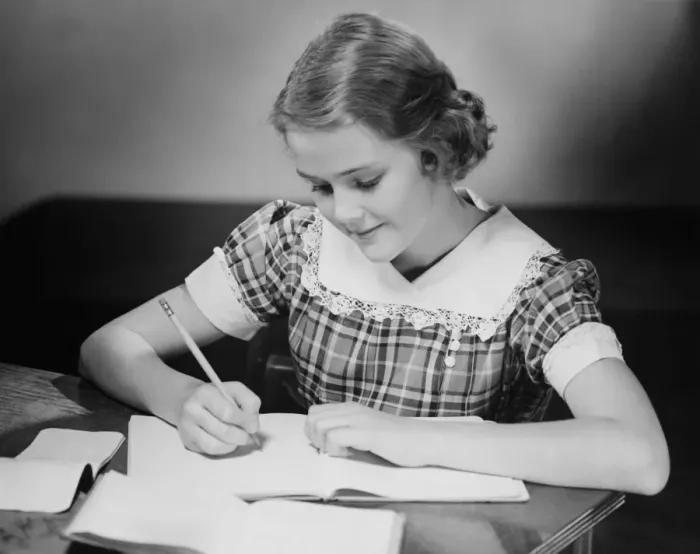 Framed Print : Young girl (12-13) at table doing schoolwork, (B&W) Framed Print : Young girl (12-13) at table doing schoolwork, (B&W)
