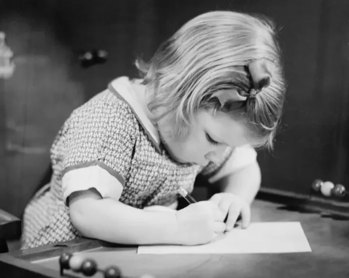 Framed Print : Young girl (4-5) working on school table, (B&W), close-up Framed Print : Young girl (4-5) working on school table, (B&W), close-up