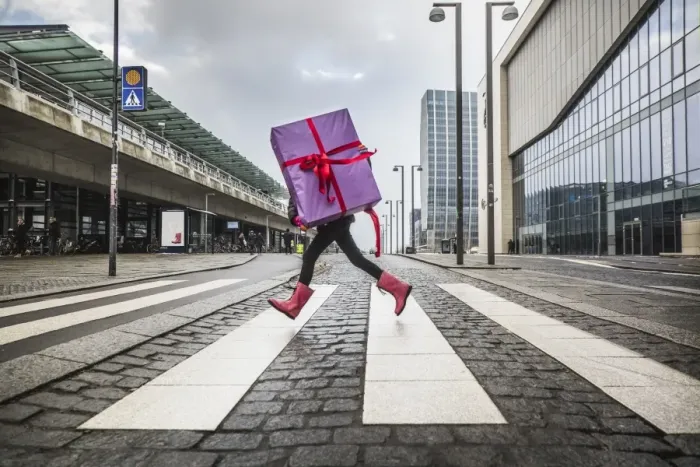Framed Print : Young girl running with large gift on street Framed Print : Young girl running with large gift on street