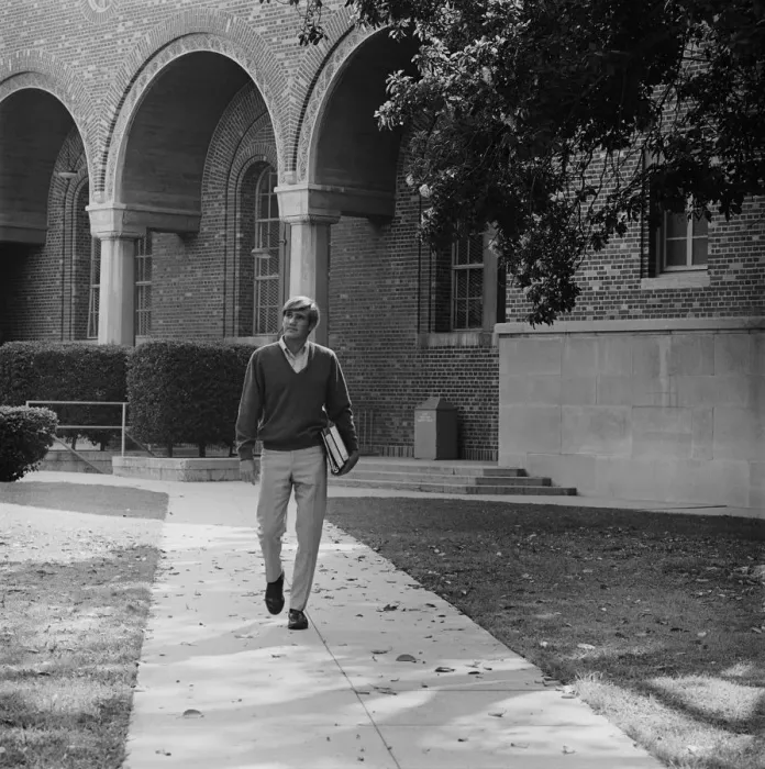 Framed Print : Young man with books walking on campus Framed Print : Young man with books walking on campus