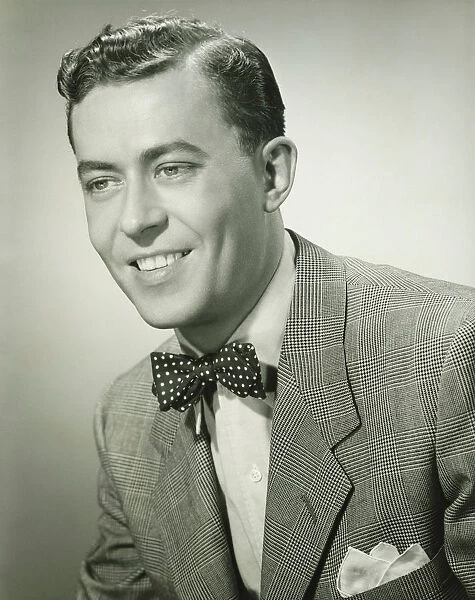 Young man in bow tie posing in studio, (B&W), (Close-up), (Portrait)