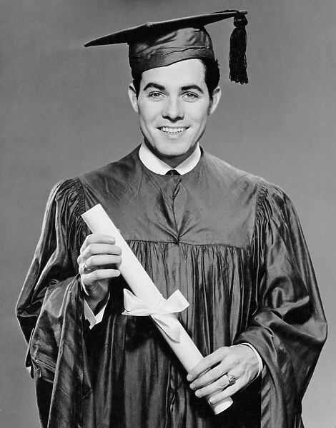 Young man in cap & gown holding diploma