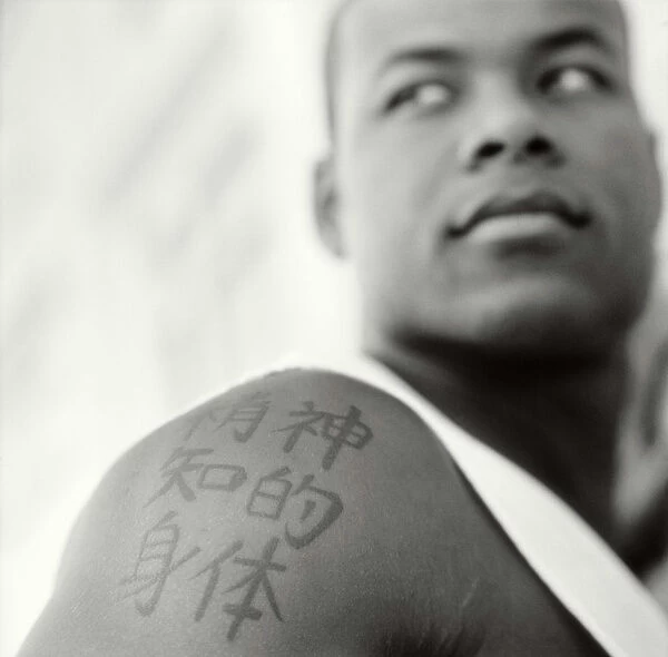 Young man with chinese characters tattooed on arm (B&W)