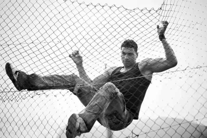 Framed Print : Young man climbing a fence Framed Print : Young man climbing a fence