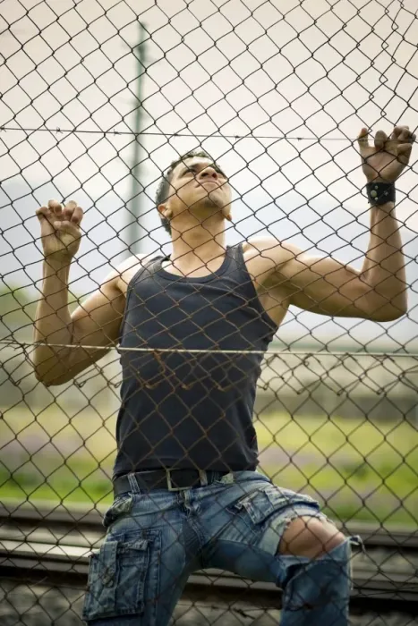 Framed Print : Young man climbing a fence