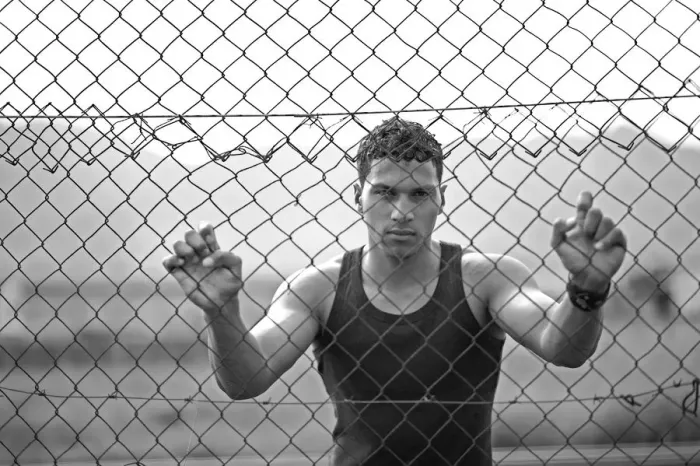 Framed Print : Young man holding onto a fence Framed Print : Young man holding onto a fence