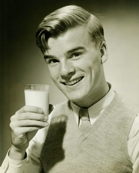 Framed Print : Young man holding glass of milk, smiling, (B&W), portrait Framed Print : Young man holding glass of milk, smiling, (B&W), portrait