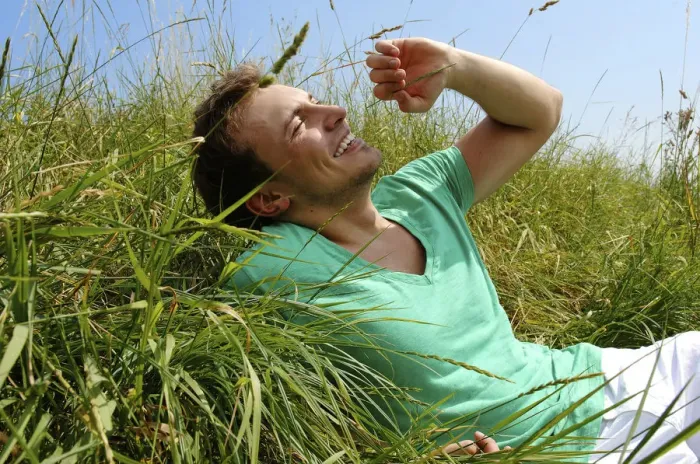 Framed Print : Young man lying in tall grass, smiling, sunbathing Framed Print : Young man lying in tall grass, smiling, sunbathing