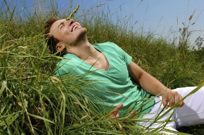 Framed Print : Young man lying in tall grass, smiling, sunbathing Framed Print : Young man lying in tall grass, smiling, sunbathing