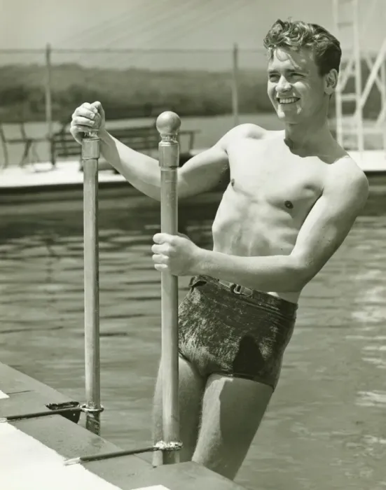 Framed Print : Young man standing on pool ladder, (B&W) Framed Print : Young man standing on pool ladder, (B&W)