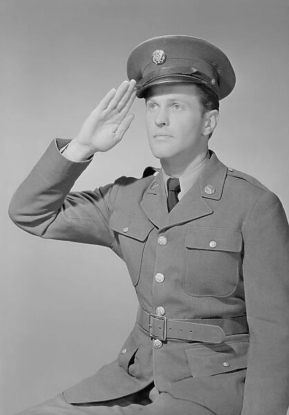 Young man in uniform saluting