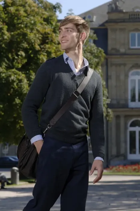 Framed Print : Young man wearing elegant clothing with a bag over his shoulder in front of the New Palace in Stuttgart, Baden-Wuerttemberg, Germany, Europe