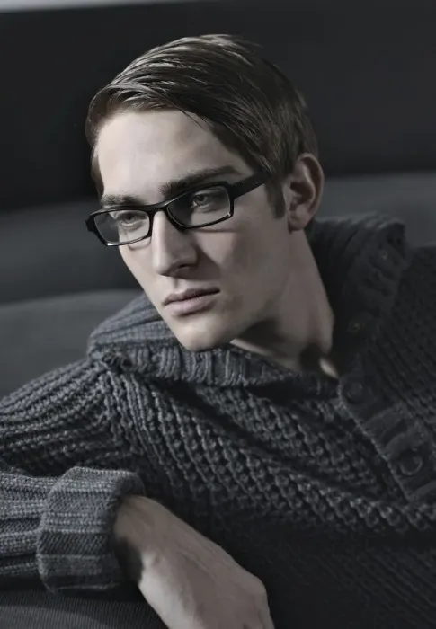 Framed Print : Young man wearing glasses sitting on a sofa