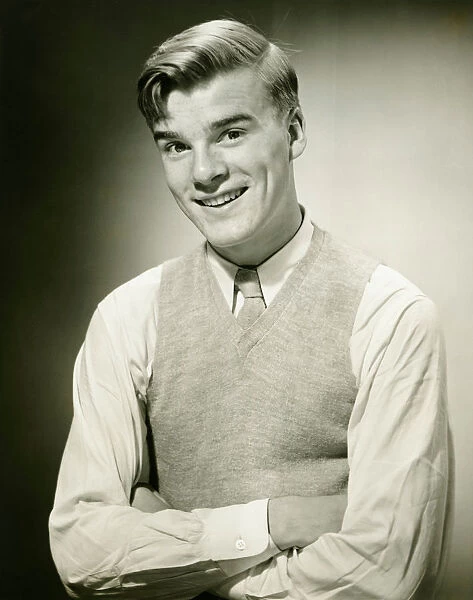 Young man wearing jumper, smiling, (B&W), portrait