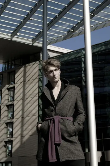 Framed Print : Young man wearing an overcoat in front of modern architecture, fashion shoot Framed Print : Young man wearing an overcoat in front of modern architecture, fashion shoot