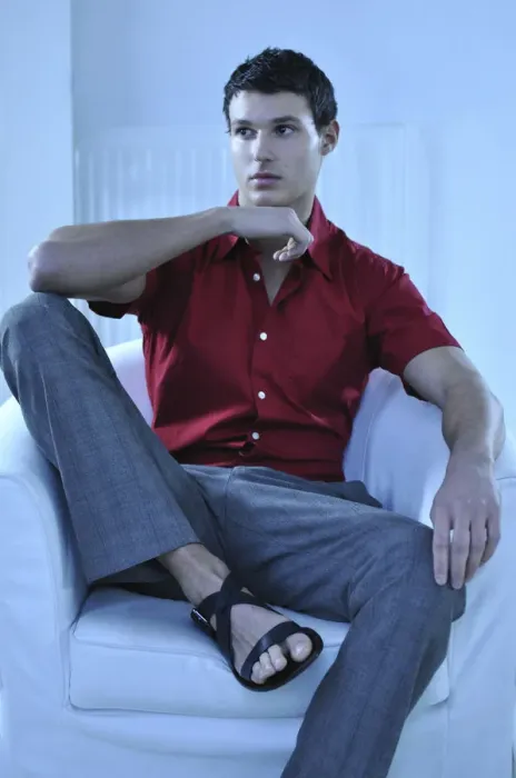 Framed Print : Young man wearing a red shirt sitting in an armchair Framed Print : Young man wearing a red shirt sitting in an armchair