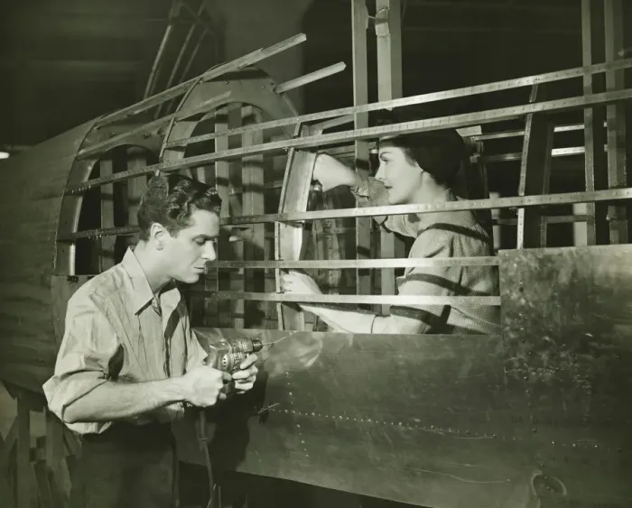 Framed Print : Young man and woman working in plane body in factory, (B&W) Framed Print : Young man and woman working in plane body in factory, (B&W)