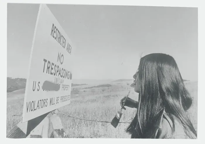Framed Print : Young Native American Painting over Government Sign Framed Print : Young Native American Painting over Government Sign