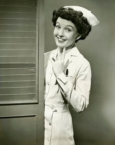 Young nurse smiling by open door, (B&W)