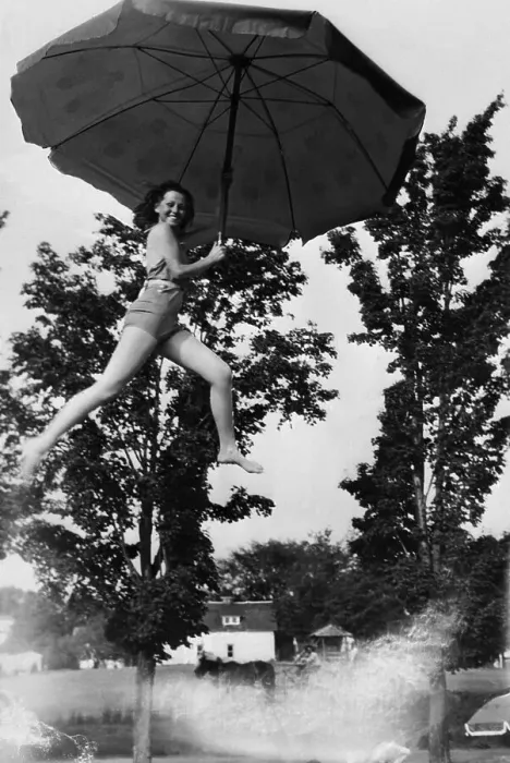 Framed Print : Young smiling woman holding umbrella in air Framed Print : Young smiling woman holding umbrella in air
