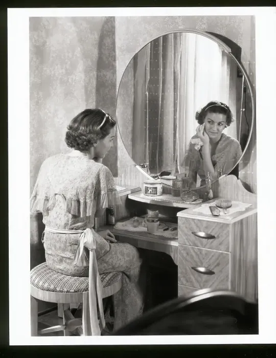 Framed Print : Young Woman Applying Face Cream at Vanity Framed Print : Young Woman Applying Face Cream at Vanity