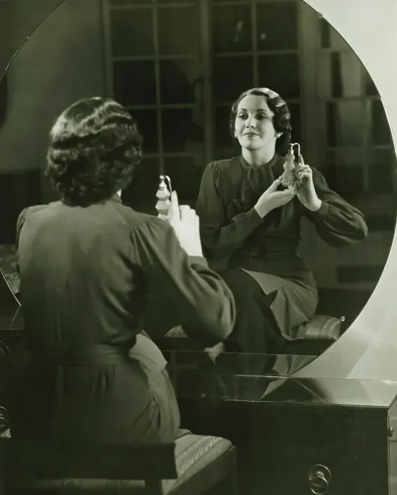 Framed Print : Young woman applying perfume in front of mirror, (B&W) Framed Print : Young woman applying perfume in front of mirror, (B&W)