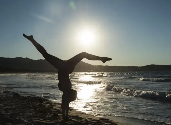 Framed Print : Young woman doing gymnastics on the beach, backlight, Corsica, France Framed Print : Young woman doing gymnastics on the beach, backlight, Corsica, France