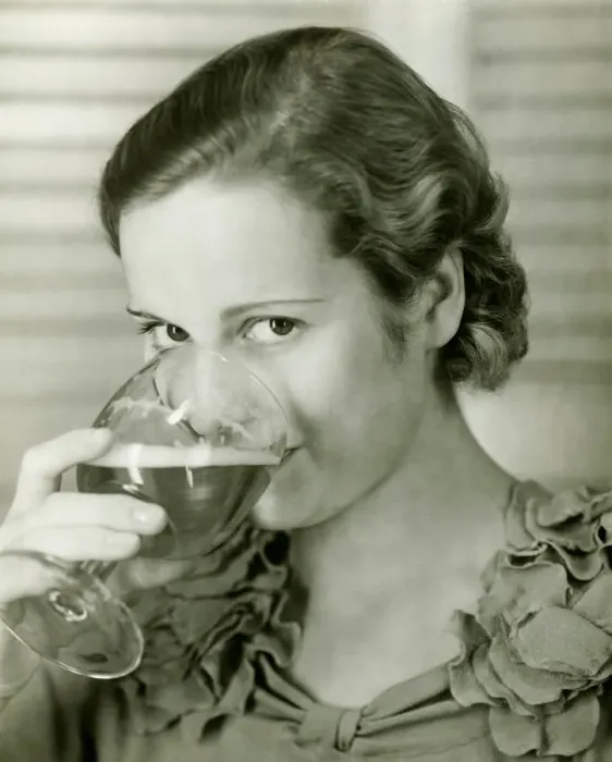 Framed Print : Young woman drinking glass of beer, (B&W), portrait