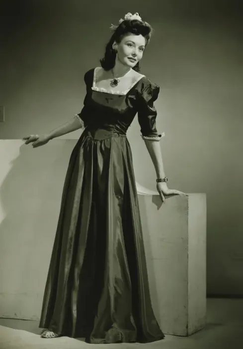 Framed Print : Young woman in evening dress leaning against low wall indoors, (B&W) Framed Print : Young woman in evening dress leaning against low wall indoors, (B&W)