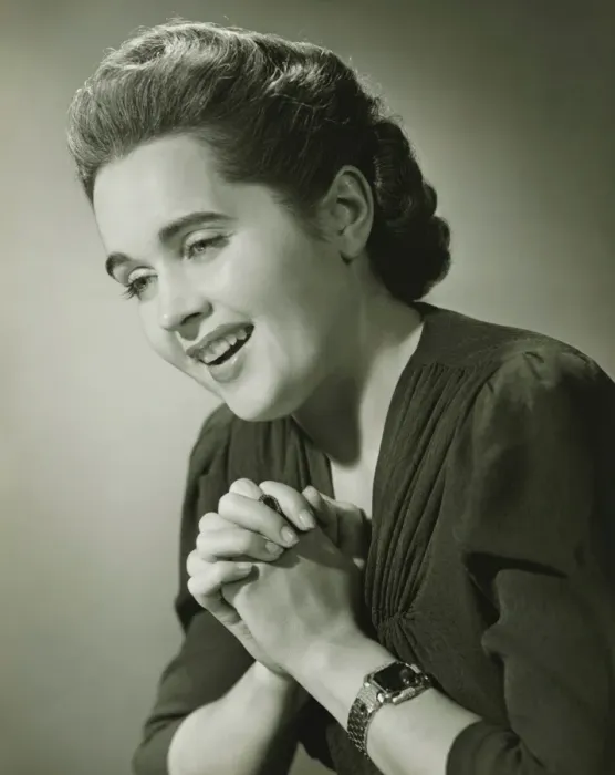 Framed Print : Young woman with hands put together smiling in studio (B&W), close-up Framed Print : Young woman with hands put together smiling in studio (B&W), close-up