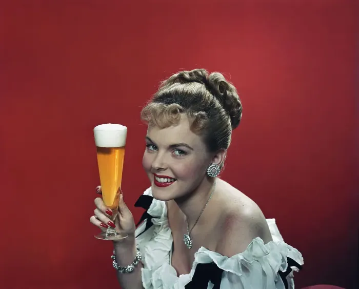 Framed Print : Young woman holding beer glass, smiling, portrait Framed Print : Young woman holding beer glass, smiling, portrait