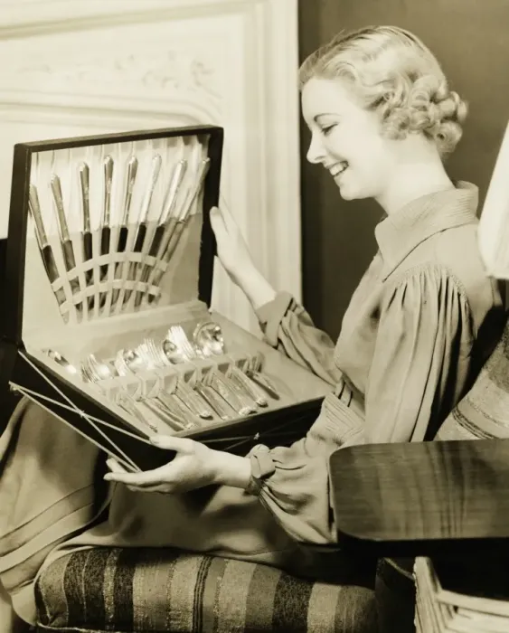 Framed Print : Young woman holding open box with cutlery, smiling, (B&W)