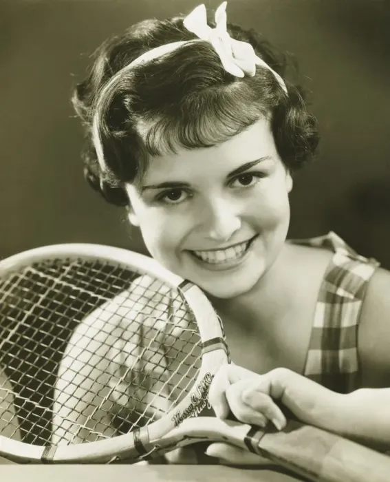 Framed Print : Young woman holding tennis racket, smiling, (B&W), portrait Framed Print : Young woman holding tennis racket, smiling, (B&W), portrait
