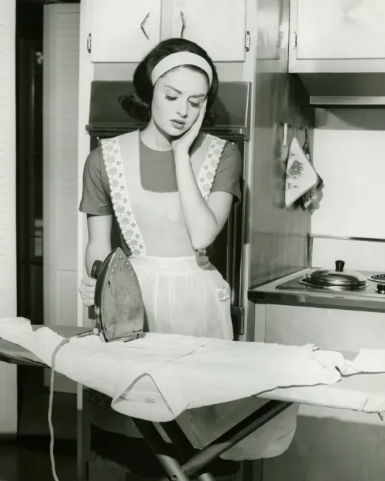 Framed Print : Young woman ironing in kitchen, (B&W) Framed Print : Young woman ironing in kitchen, (B&W)