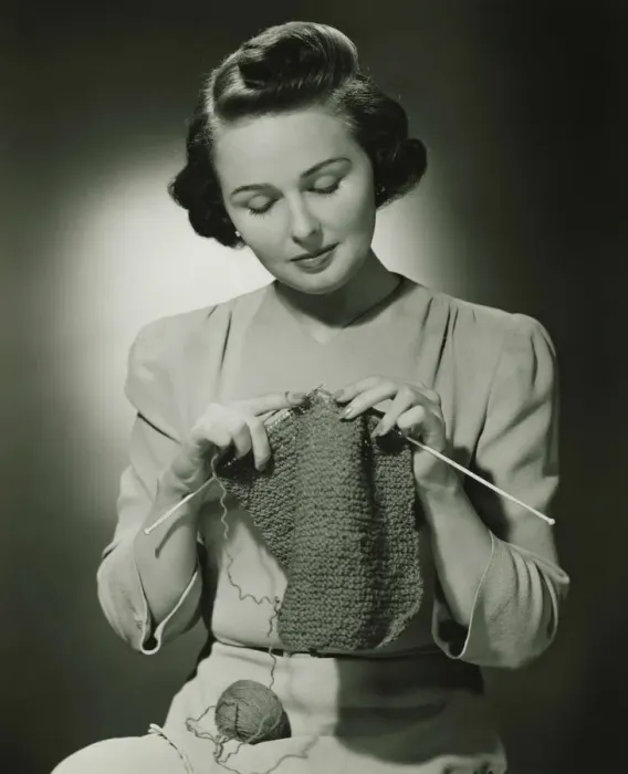 Framed Print : Young woman knitting in studio, (B&W) Framed Print : Young woman knitting in studio, (B&W)