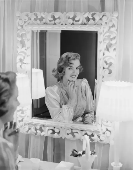Framed Print : Young woman looking in mirror, smiling Framed Print : Young woman looking in mirror, smiling