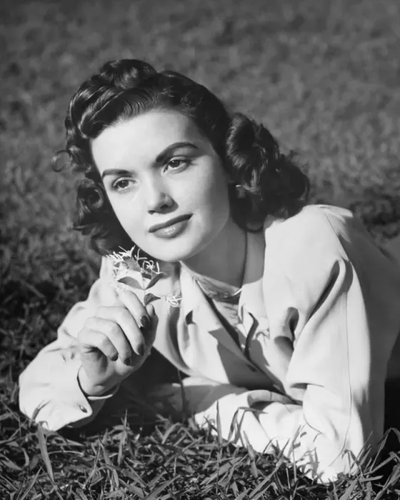 Framed Print : Young woman lying on grass, holding flower, (B&W), (Portrait) Framed Print : Young woman lying on grass, holding flower, (B&W), (Portrait)