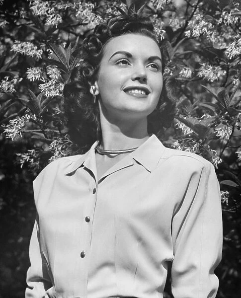Young woman posing by blooming tree, (B&W), (Close-up), (Portrait), (Low angle view)