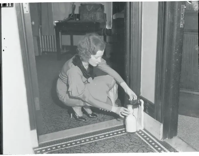 Framed Print : Young Woman Retrieving Her Protected Milk from Doorstep Framed Print : Young Woman Retrieving Her Protected Milk from Doorstep