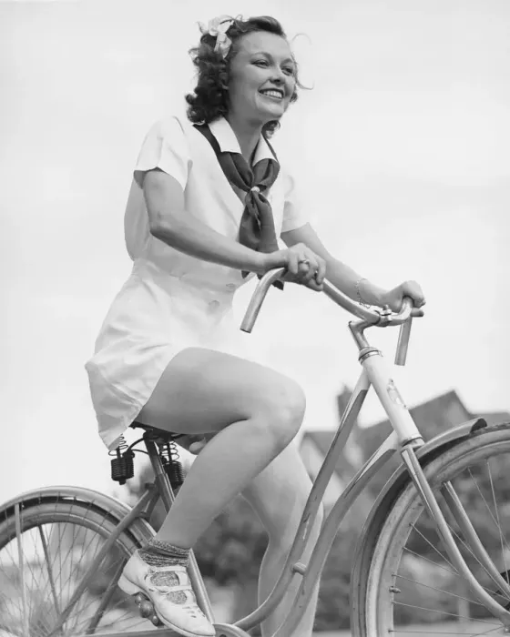 Framed Print : Young woman riding bicycle, (B&W), low angle view